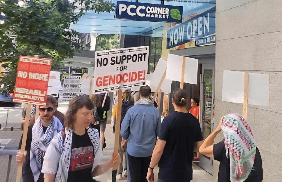 Photo of workers and socialists rally outside a PCC Community Market store in Seattle. Signs say: 